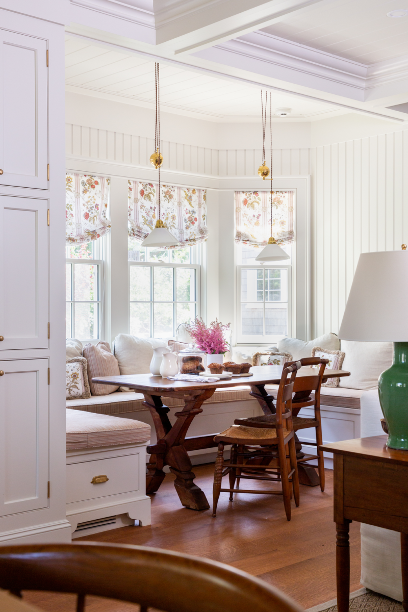 In the kitchen, a bay window becomes a dining banquette, where the HVAC grill is tucked into one of the seats.